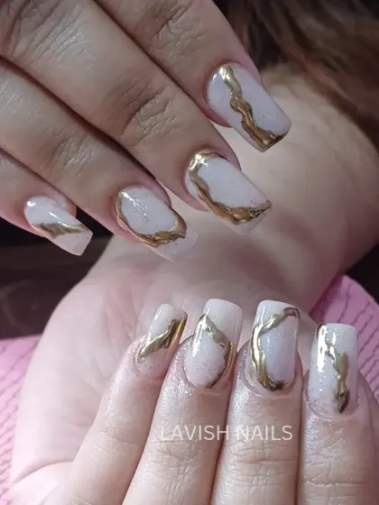 An abstract design featuring textured, molten gold chrome over a sheer, shimmery base on square nails.