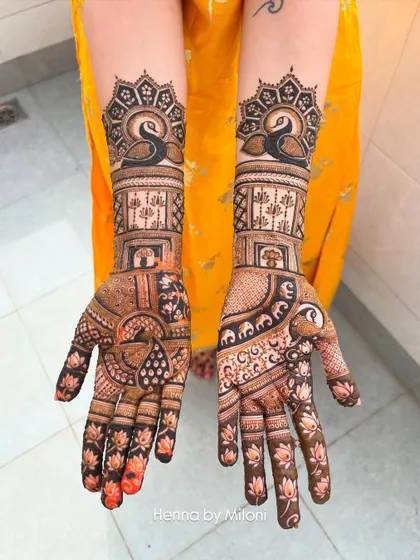 A stunning minimal bridal design. This look features elegant swans on the forearm and a mix of lotus motifs and geometric patterns on the palms.