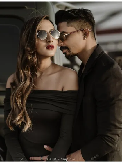 An intimate close-up of the stylish couple, their sunglasses and confident expressions creating a cool, editorial vibe for their desert pre-wedding shoot.