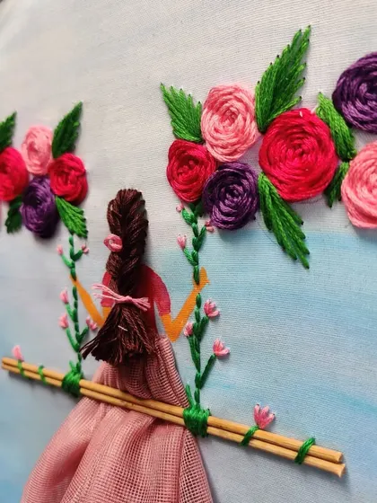 A full view of the girl on the swing embroidery piece.