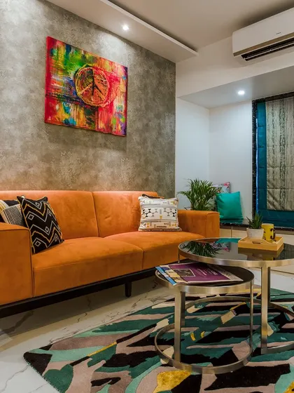 Another example of a living room with a bold orange sofa, complemented by a geometric rug and abstract art, creating a space full of energy and personality.