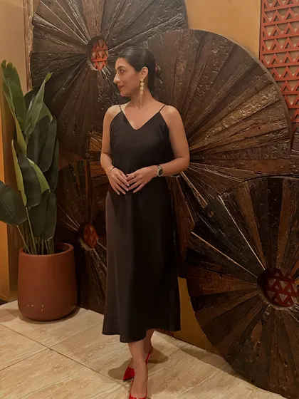 Posing against a wooden backdrop in my brown dress. This outfit is a reminder that life is happening now.