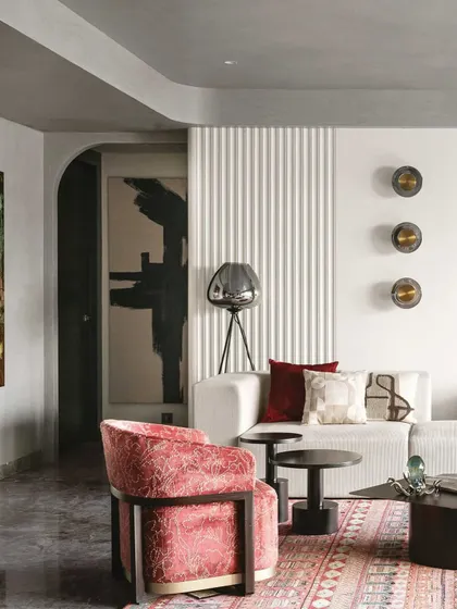 This view shows the interplay of different textures in one living space. The fluted wall panel, the plush velvet armchair, and the patterned rug all work together to create a room that is visually rich and interesting from every angle.