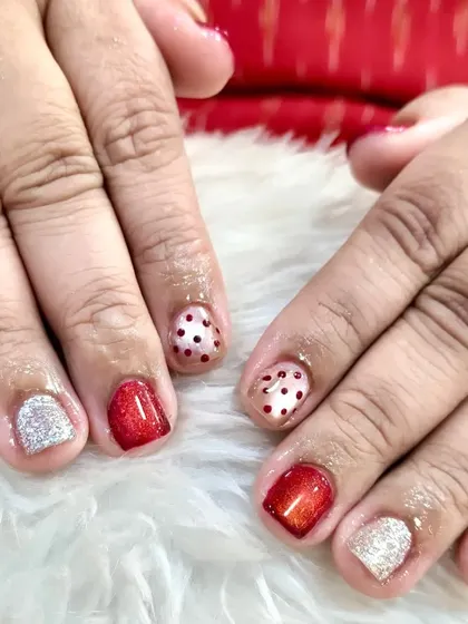 Small nails, big Christmas vibes. This shows that even on tiny nails, you can have a huge festive impact with cute reds, sparkles, and Christmas dots.