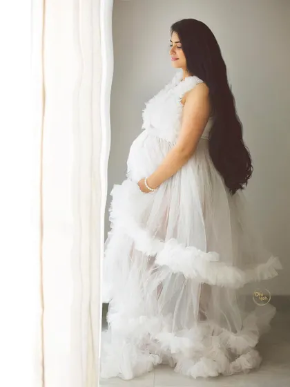 Using the soft light from the studio window, we can create serene and thoughtful portraits. This image captures a moment of peaceful connection between a mother and her unborn baby.
