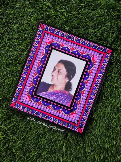 A custom-made souvenir featuring a hand-painted mandala border around a photograph. This is a wonderful way to turn a cherished memory into a unique piece of decorative art.