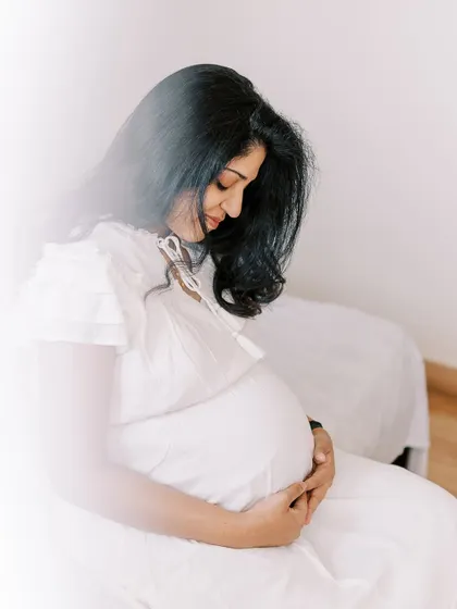 A serene solo portrait of the mother-to-be, with a soft, hazy light effect. This artistic choice adds a dreamy quality to the image, perfect for a maternity photo.
