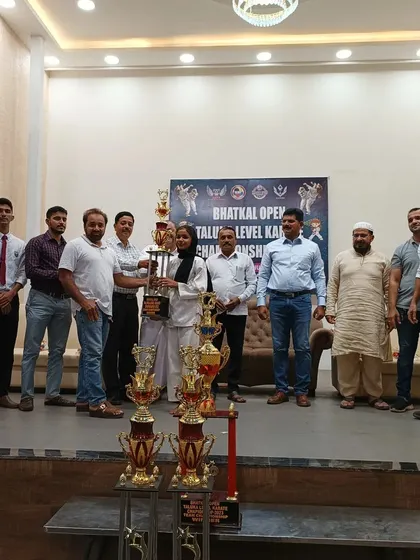 We celebrate every victory. Here, our student stands proud with her Grand Championship trophy, surrounded by coaches and supporters who are part of her success.