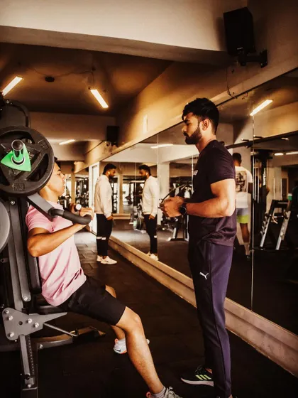 Guiding a client through a shoulder press machine. My focus is always on teaching proper form and technique to ensure every rep counts and is performed safely.