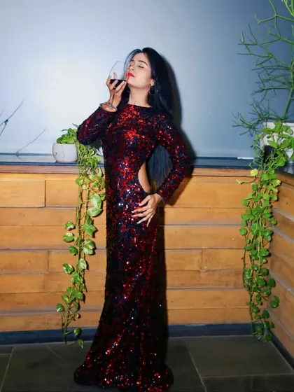 A model looking fierce in a custom red and black sequin gown. This dress features a side cutout for a bold and modern touch, perfect for a party or red carpet event.
