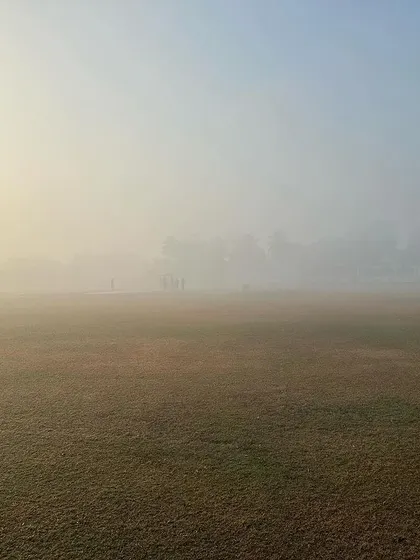 The sun trying to break through the morning fog over the field.