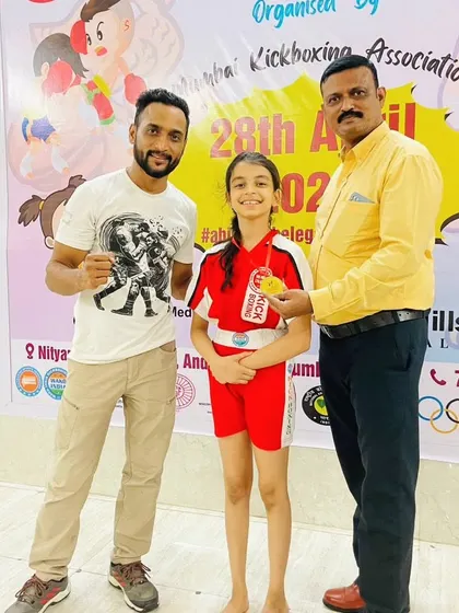 A young champion receives her medal. We prepare our students, including young girls, to compete with confidence and skill in their respective kickboxing categories.