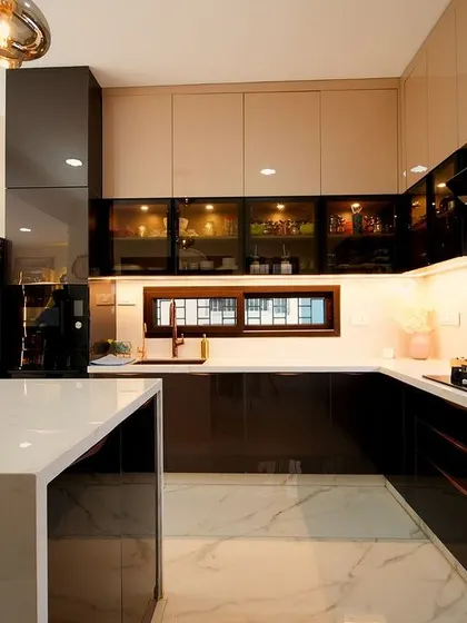 The kitchen in Rakesh and Supriya's villa, where high-gloss finishes and a waterfall island countertop create a space that is perfect for a family that loves to cook and entertain.