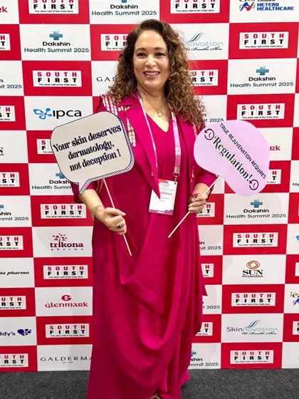 Holding up signs that reflect my core beliefs: "Your skin deserves dermatology, not deception!" and "True rejuvenation requires regulation!" at the Dakshin Health Summit.