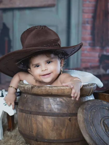 A happy cowgirl enjoying her time in the barrel, ready for some fun on the farm.