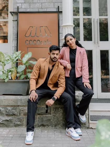 A stylish portrait of a couple posing in front of a chic cafe in Mumbai. Their modern outfits and confident poses are perfect for a contemporary pre-wedding album.