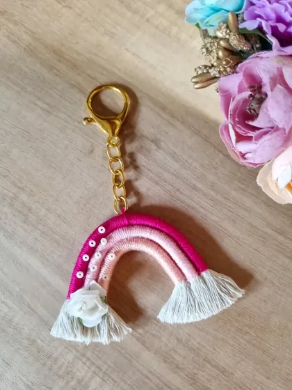 This macrame rainbow keychain in shades of pink is a perfect little gift for your loved ones, or for yourself. The small flower detail adds an extra touch of cuteness.