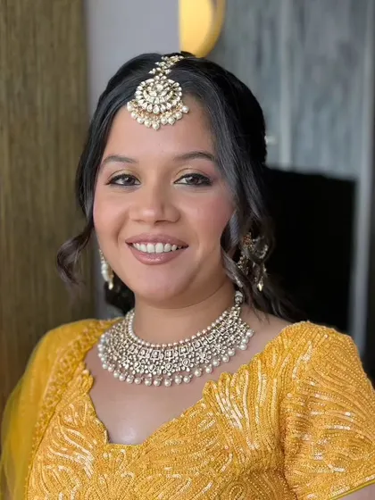Simplicity meets sparkle. This look for a Haldi ceremony features soft, shimmery eyes and a natural lip, paired with a bright yellow outfit.