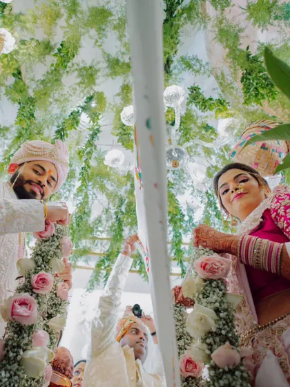 A unique low-angle shot looking up at the couple during a Maharashtrian wedding ritual.
