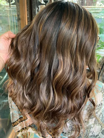 This is a swirled chocolate butterscotch look. I used a non-bleach formula to tone her previously lightened hair and add in a mix of light browns and caramel. The before and after is stunning.