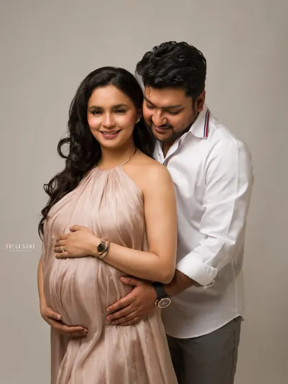 An elegant maternity portrait of a couple. The soft, flowing fabric of her dress and the gentle light create a feeling of quiet beauty and anticipation.