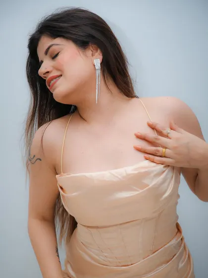 A soft and delicate studio portrait, capturing a moment of serene happiness. The simple background keeps the focus on the model.