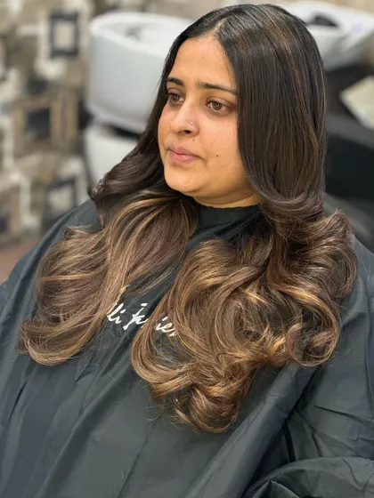 Feel the magic in the hair. This client's long, dark hair was transformed with a warm balayage, creating a rich and luxurious look.