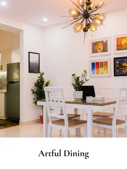 A bright and artful dining space where modern white furniture is paired with a gallery wall of colorful paintings. A sculptural sputnik chandelier adds a touch of mid-century flair, creating a welcoming and inspiring setting.
