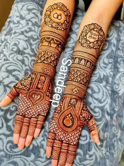 A modern take on personalization. This design features the couple's initials and wedding rings within ornate circular frames on the forearms, while the palms have contemporary heart and teardrop shapes filled with fine latticework.