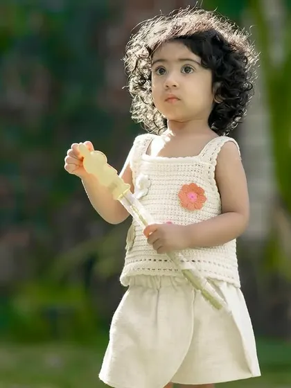 A little girl enjoying a sunny day in the garden, getting ready to blow some bubbles. We love capturing these simple childhood joys.