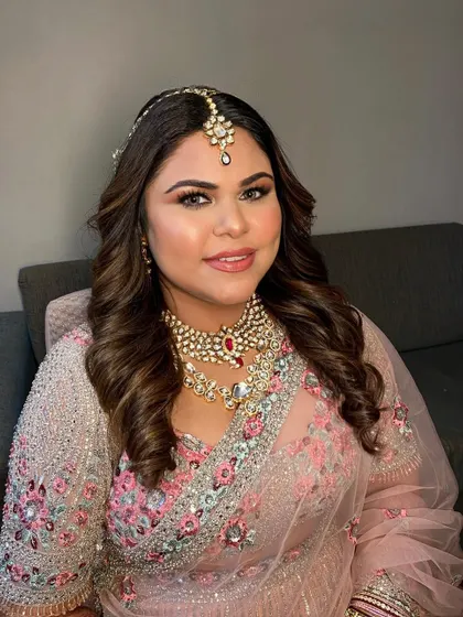 A beautiful bride ready for her wedding. The soft pink and silver lehenga is paired with a gentle smokey eye and glowing skin.
