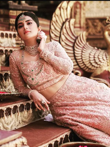 The stunning actress Megha Shetty looking regal in my custom pink bridal lehenga. The intricate embroidery and diamond jewelry create a look of pure bridal opulence.