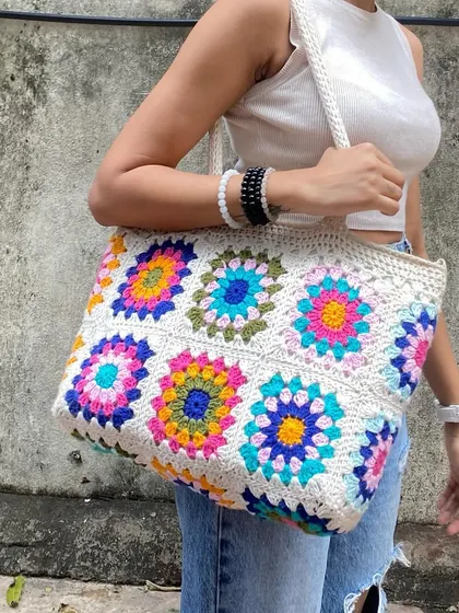 This is our spacious granny square tote bag, our absolute bestseller. It's inspired by the colorful designs you see all over Pinterest and is roomy enough to carry your world. We make each floral square by hand, and you can even customize the colors.
