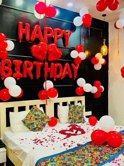 Another angle of the red and white romantic bedroom setup, showing the "Happy Birthday" and heart-shaped foil balloons above the bed.