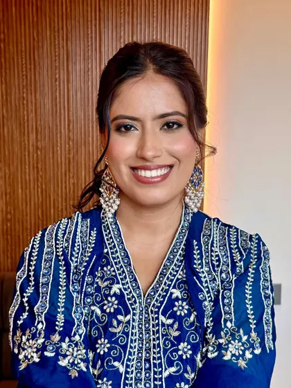 A smiling portrait of the bride. The soft glam makeup enhances her features without looking heavy, perfect for a daytime event.