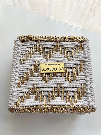 This intricate white and gold woven box showcases our commitment to unique packaging. The custom metal plaque with our branding is a mark of quality and thoughtful curation.