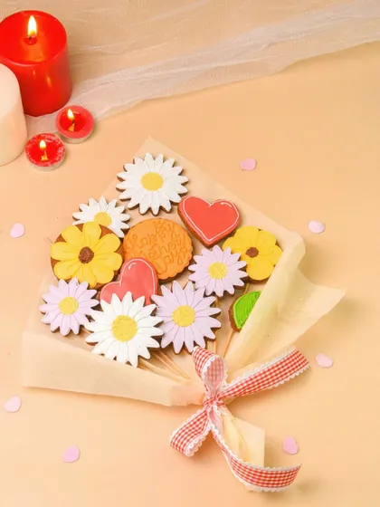Another angle of the cookie bouquet, styled with soft fabric and candles. This creates a warm and celebratory mood.