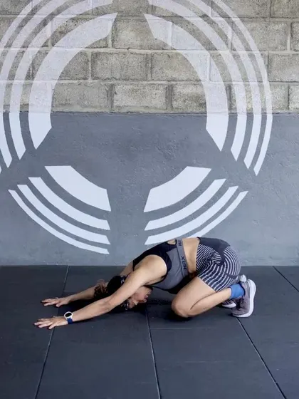A member in the Child's Pose, demonstrating a moment of rest and recovery within a flow.