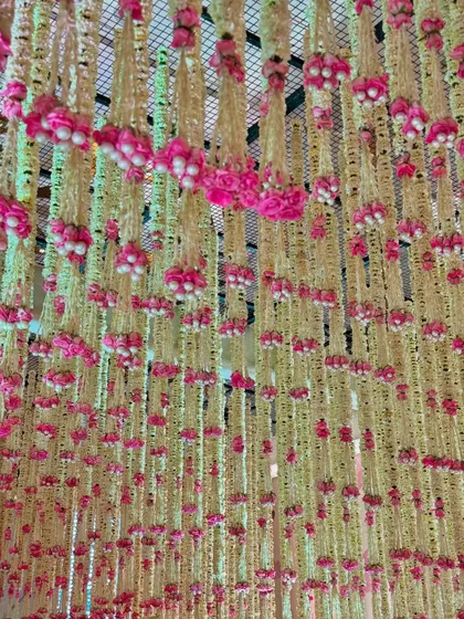 A close-up of the hanging floral strings, a signature element in our traditional decor. The combination of white and pink is both classic and celebratory.