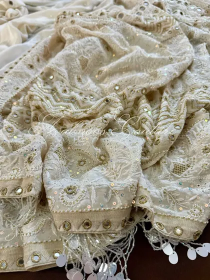 A close-up of the draped fabric, showing the intricate details of the embroidery and mirrorwork.