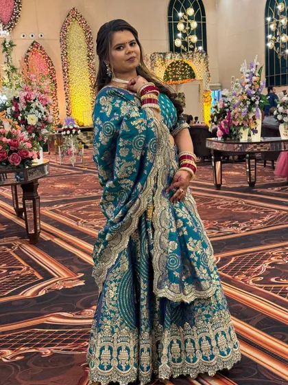 A full-length view of the teal brocade lehenga. The heavy gold work on the border and dupatta gives it a luxurious feel, making it a great rental for a special occasion.