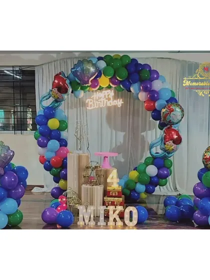 A mermaid-themed party with a circular balloon arch and mermaid-shaped foil balloons.
