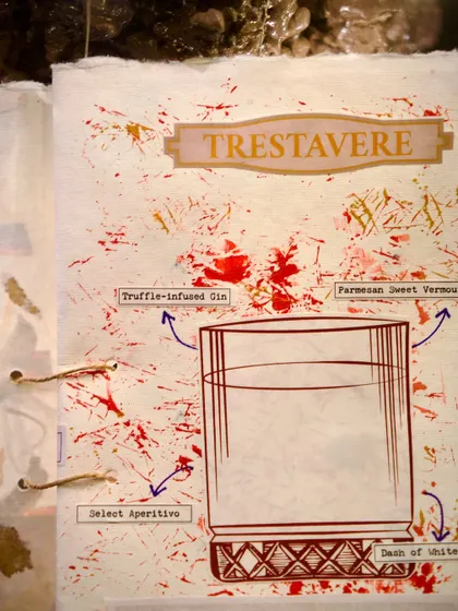 The 'Trestavere' cocktail, a truffle-infused gin drink, as seen in our handmade menu. The artistic splatter design and ingredient callouts make exploring the menu an engaging experience in itself.
