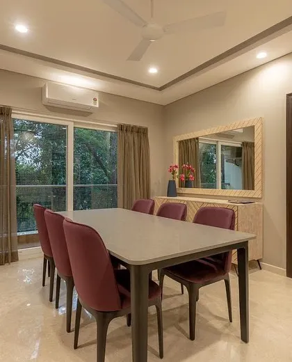 Another view of the dining room, showing its connection to a balcony that fills the space with natural light.