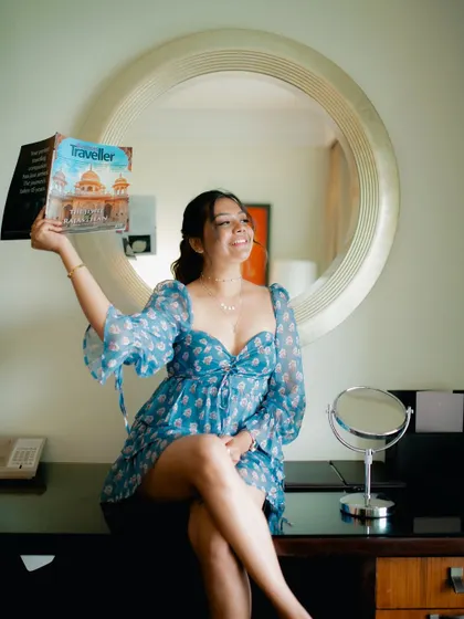 A playful and happy portrait of a model with a magazine. Her bright smile and the indoor setting create a fun and engaging lifestyle shot.
