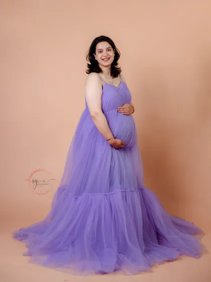 A classic and radiant solo portrait. The mom-to-be cradles her bump, her smile full of joy and anticipation.
