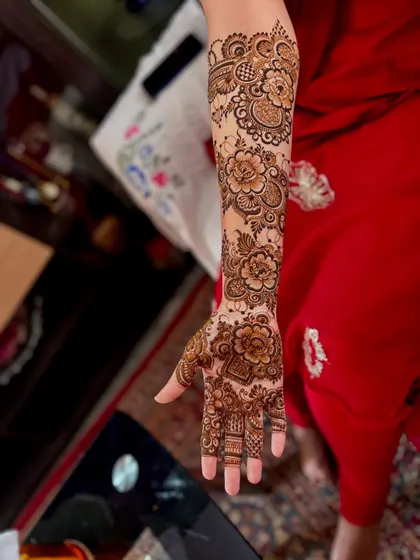 A single arm view of bride Huma's floral henna, showing the detail and shading in each flower. This style is perfect for brides who love botanical themes.
