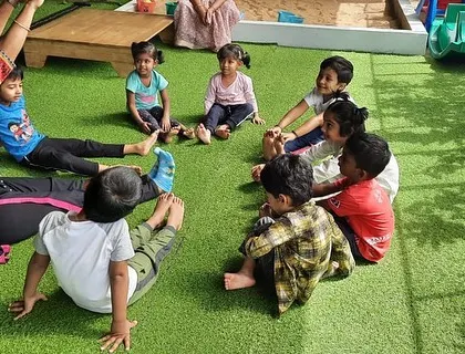 A group of children in our outdoor area, engaged in a guided yoga session. The fresh air and natural surroundings enhance the calming effects of the practice.