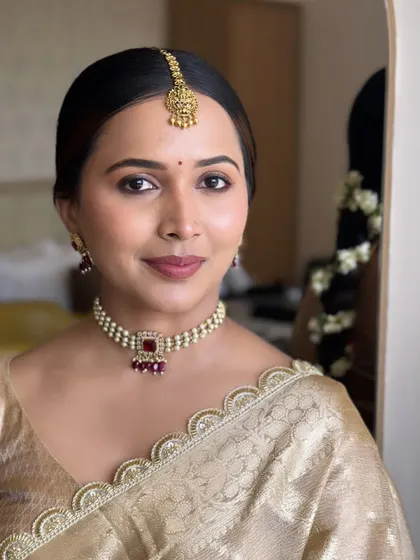This portrait showcases a soft, natural bridal makeup look. The skin is luminous, the eyes are gently defined, and the lip color is a soft nude, perfect for a bride who wants an understated look.