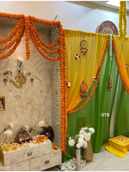 A close-up of a home mandir I decorated for a pre-wedding pooja. I used marigold torans and draped yellow and green fabric to create a sacred and beautiful space.